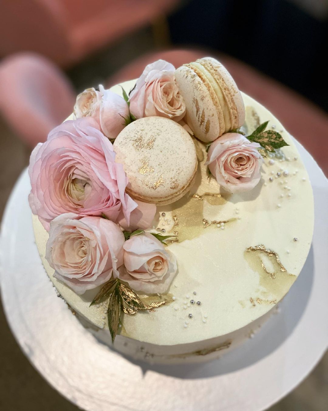 Кремовый торт украшенный макарунами и цветами