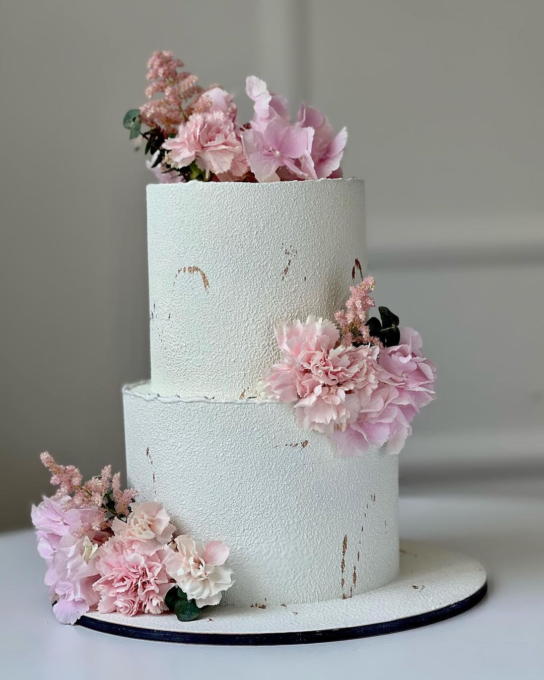 Двухъярусный торт украшенный пышными цветами